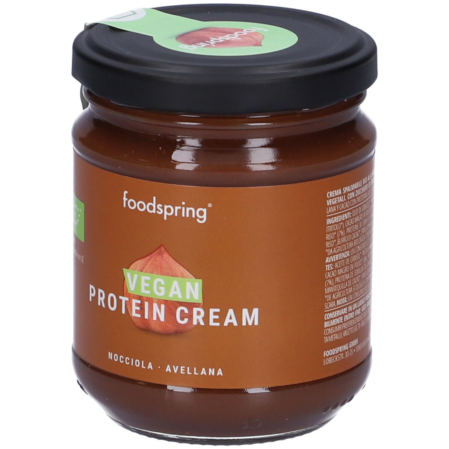 Vasetto Foodspring Bio Crema Proteica Vegana Alla Nocciola. Etichetta marrone con testo e logo. Coperchio con sigillo verde.