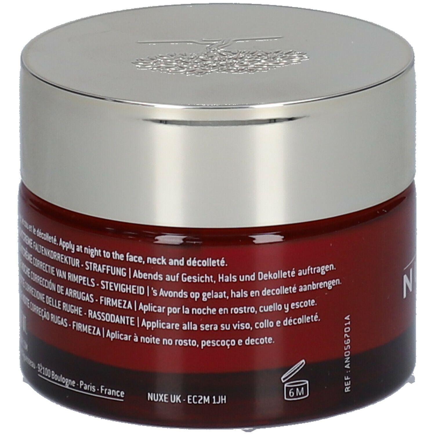Vaso di crema rosso scuro con coperchio argentato. Testo multilingue. Scritta: Nuxe Paris, 6M.