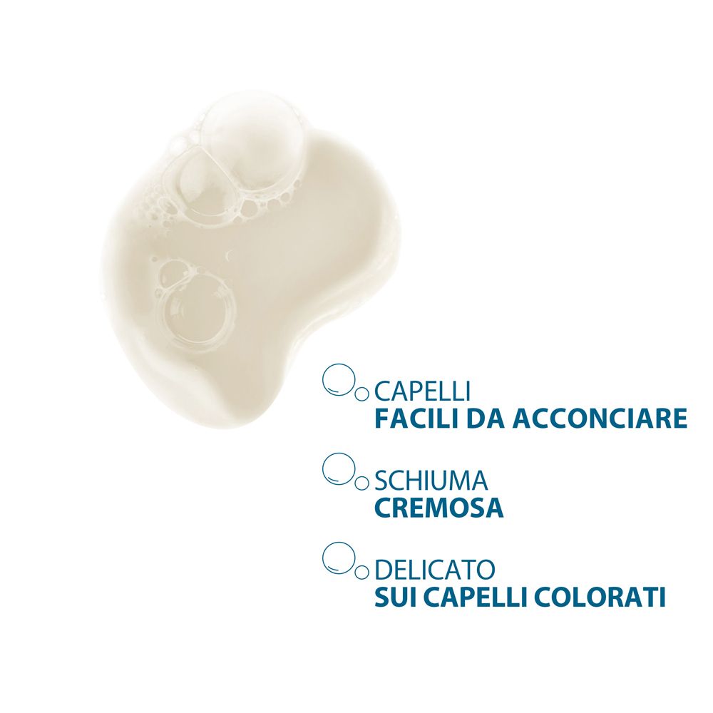 Primo piano di una sostanza cremosa. Testo: Facile da pettinare, schiuma cremosa, delicato sui capelli colorati.