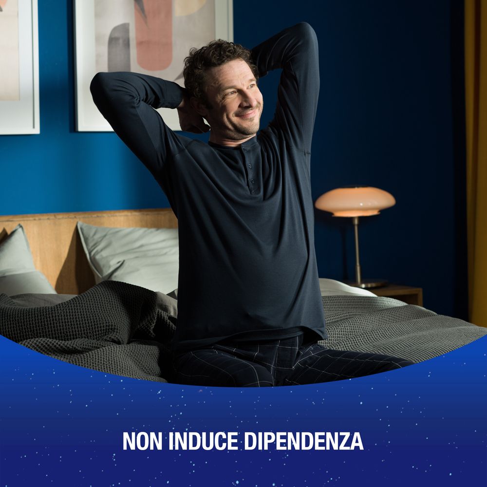 Uomo seduto sul letto, sorridente. Testo: NON INDUCE DIPENDENZA (non crea dipendenza).