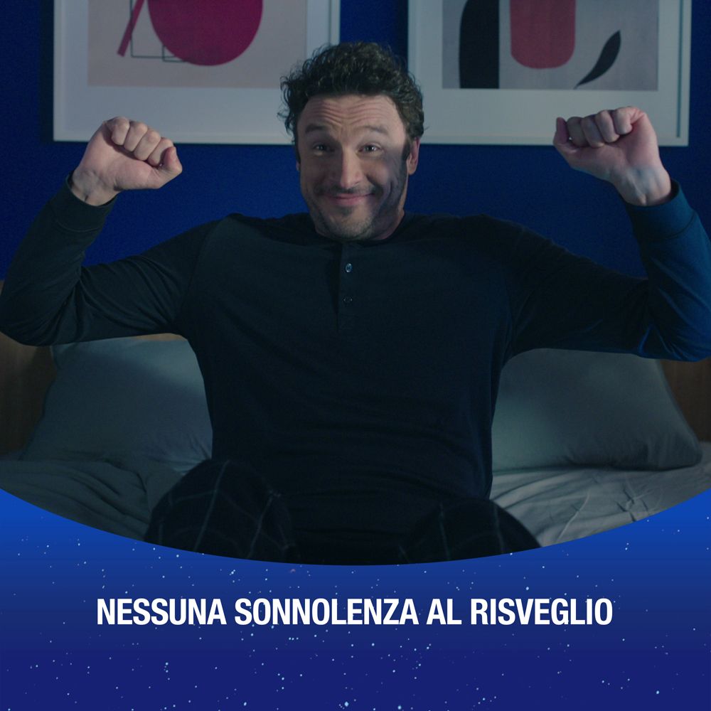Uomo seduto sul letto, alza le braccia. Testo: NESSUNA SONNOLENZA AL RISVEGLIO (nessuna sonnolenza al risveglio).
