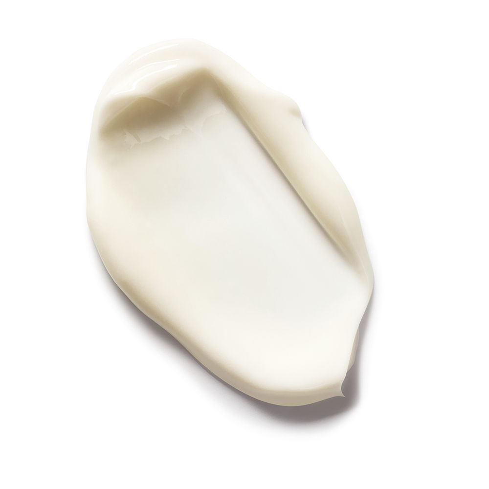 Macchia di crema bianca su sfondo bianco. Consistenza visibile.