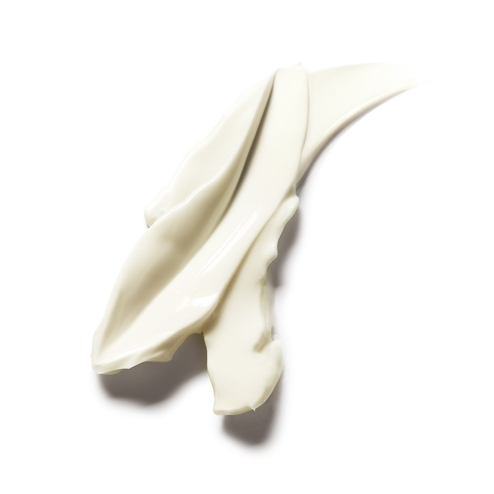 Gros plan de stries de crème sur fond blanc. La crème est blanche et brillante.