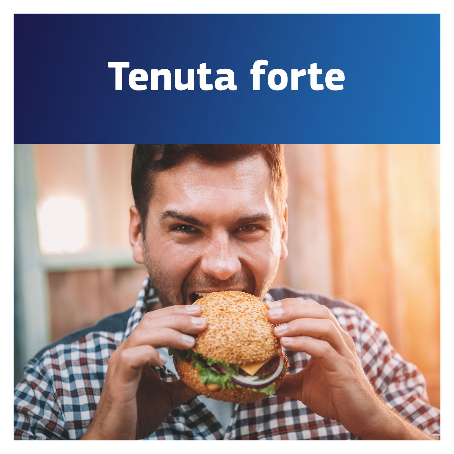Uomo che mangia un hamburger. Testo: Tenuta forte.