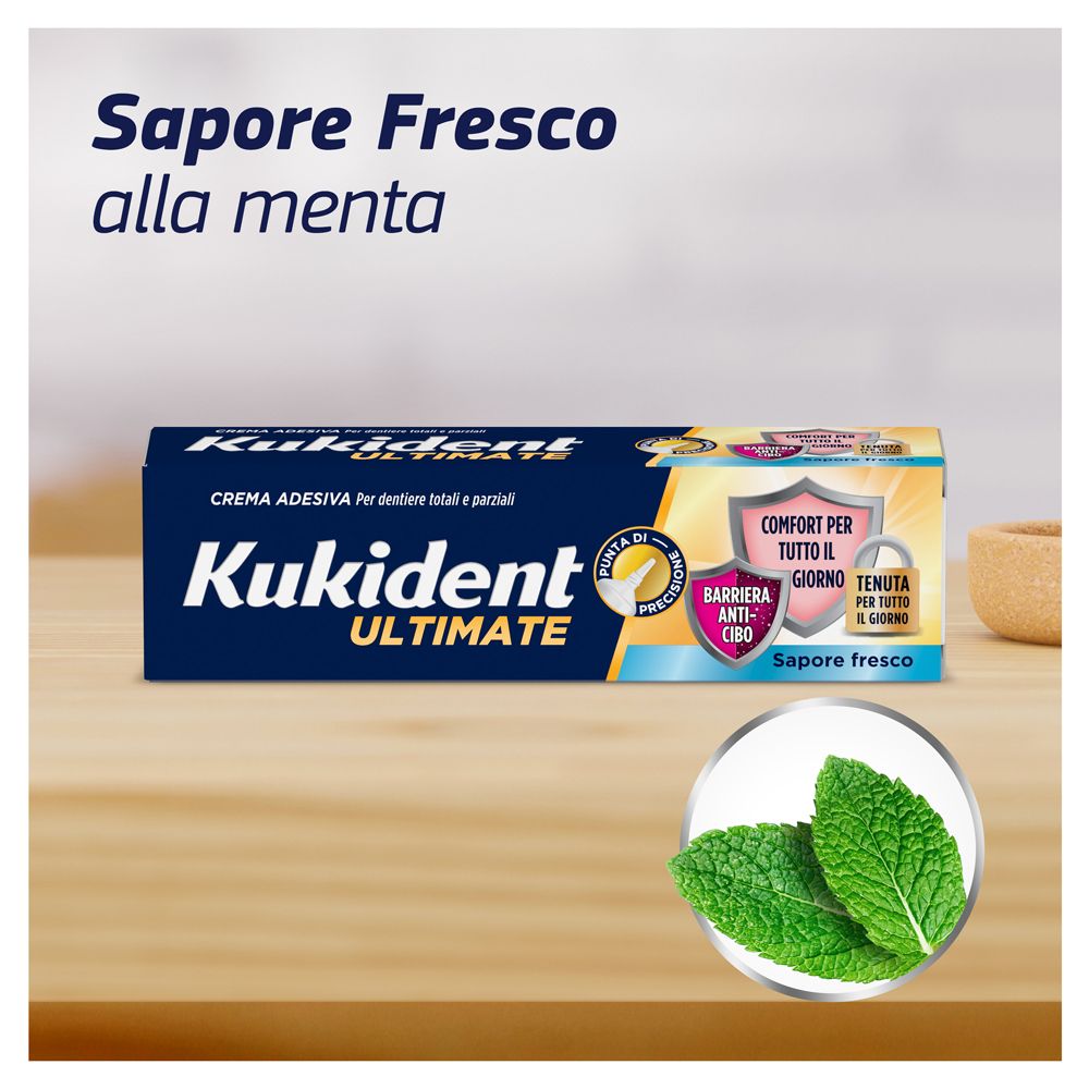 Scatola Kukident Ultimate su legno. Foglie di menta. Testo: Sapore Fresco alla menta.