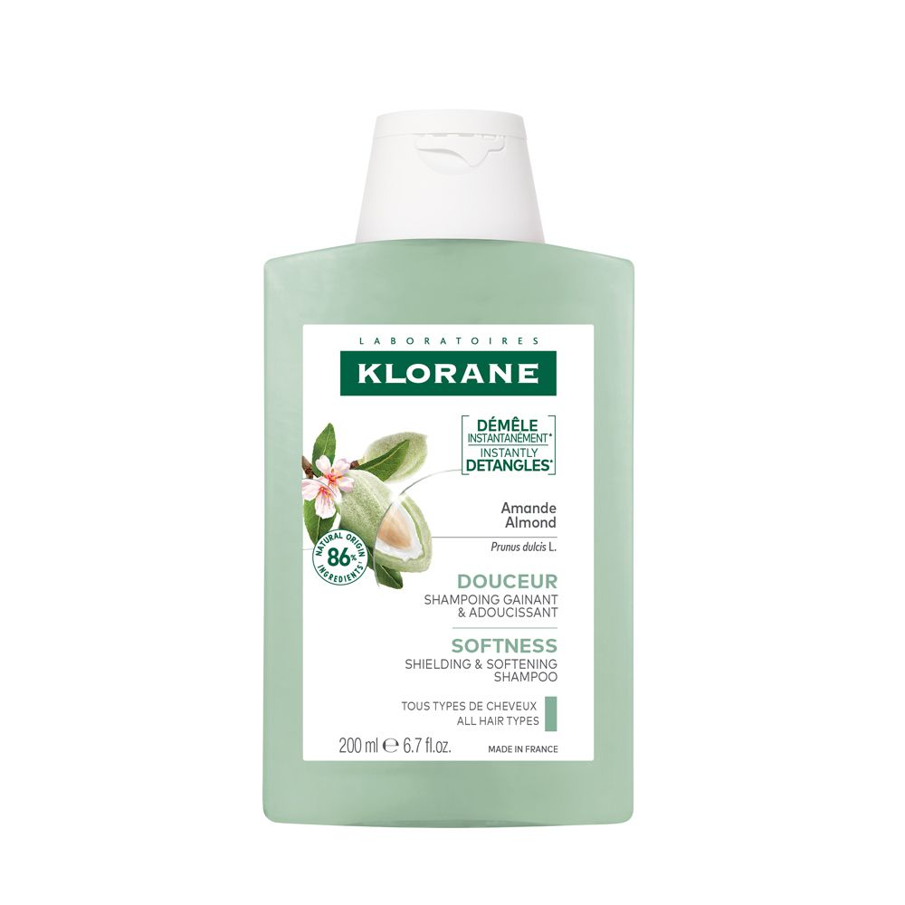 Grüne Shampoo-Flasche mit weißem Deckel. Logo: Klorane. Text: Mandel, Weichheit, 200 ml, 6.7 fl. oz. Blüten- und Mandel-Illustration.