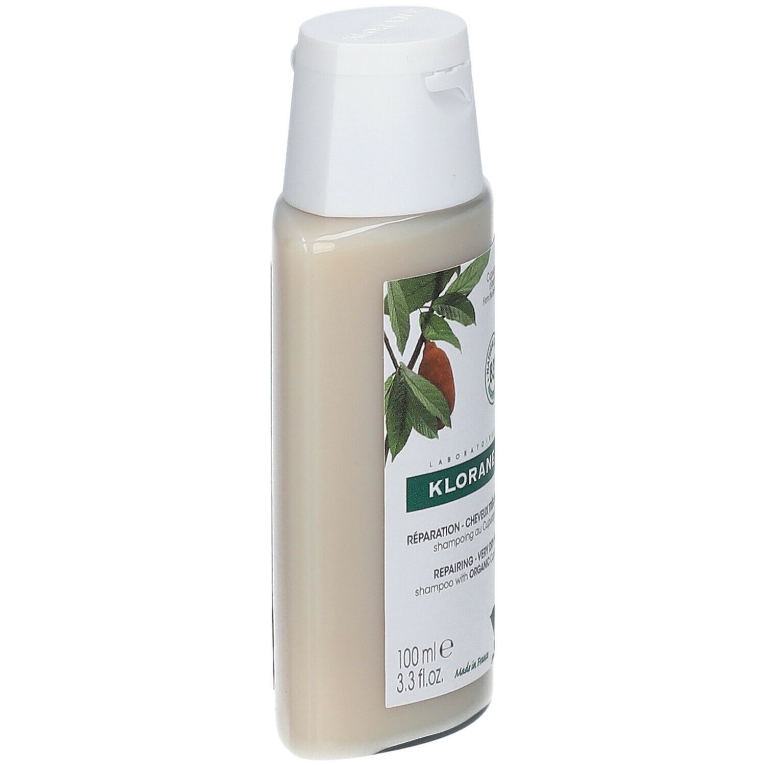 Flacone di shampoo Klorane, tappo bianco. Etichetta con testo e logo. Vista laterale.