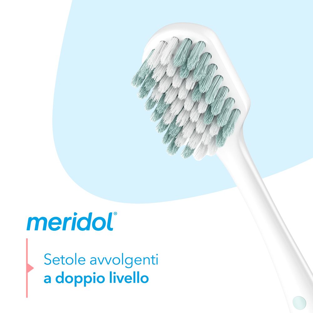Primo piano della testina. Setole bianche e verde chiaro. Testo: 'Meridol'.