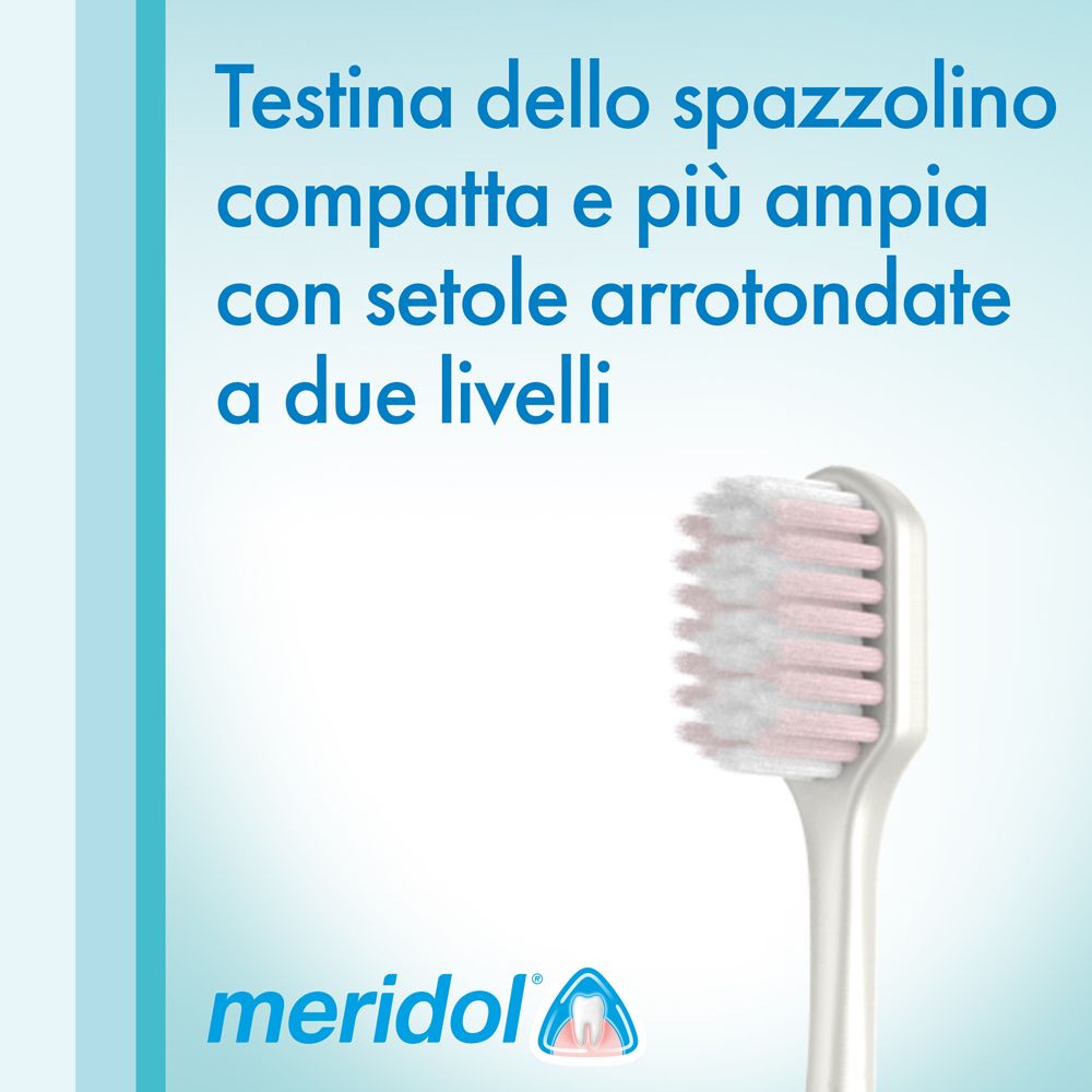 Primo piano della testina. Setole bianche e rosa. Testo: 'Meridol'.
