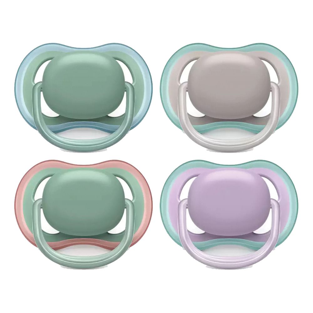 Quattro succhietti colorati: verde, rosa, viola e blu. Ognuno ha un bordo colorato e una tettarella rotonda.