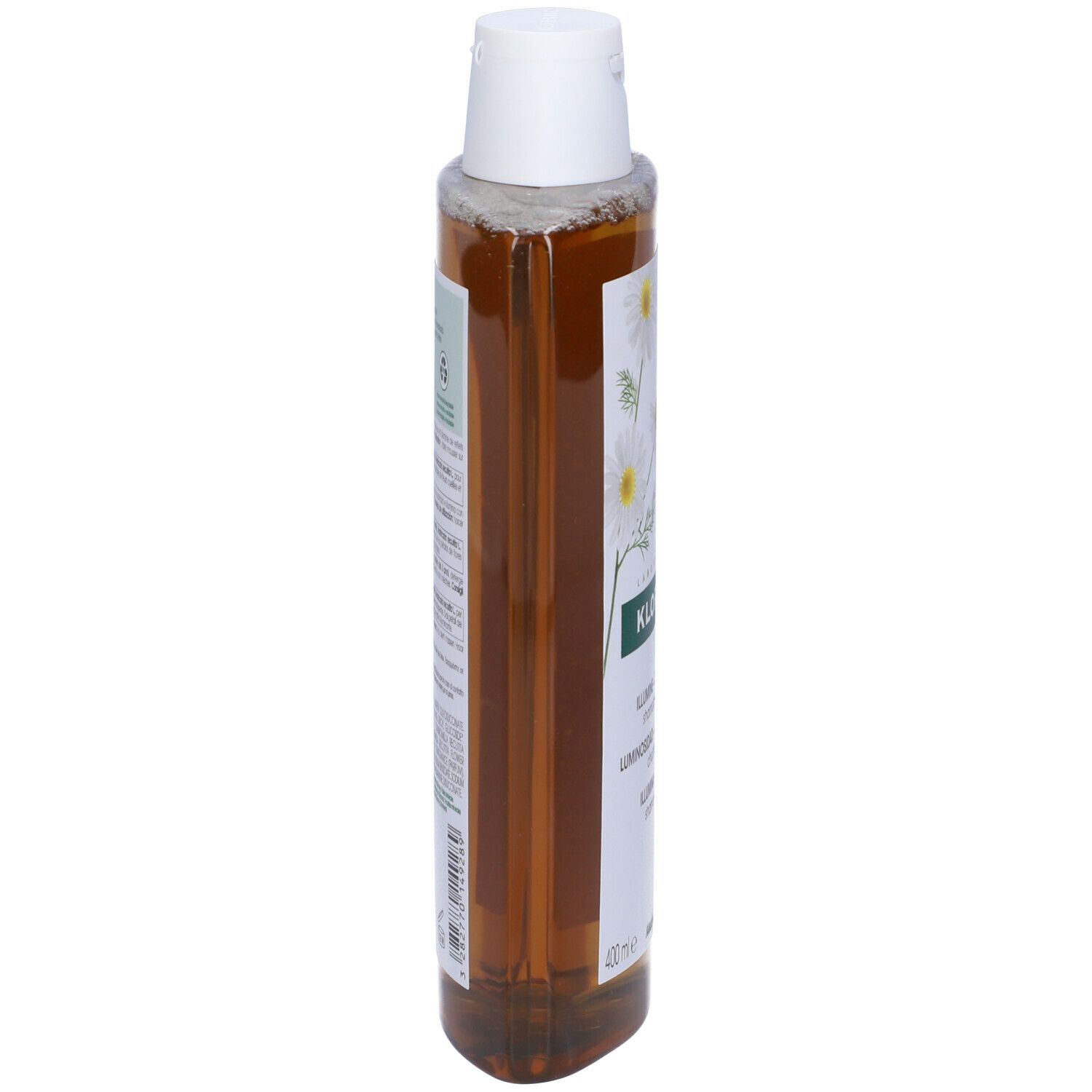 Flacone di shampoo Klorane, vista laterale. Liquido giallo, tappo bianco. Etichetta con testo e fiori di camomilla. 400 ml.