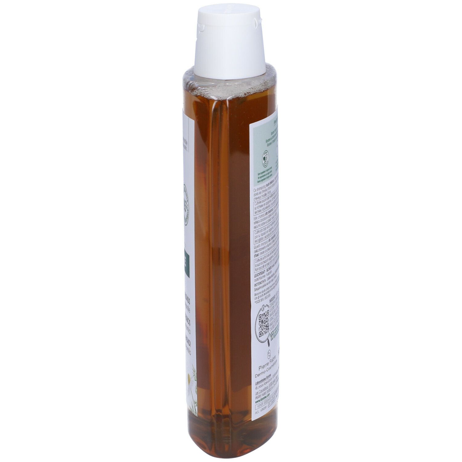 Flacone di shampoo Klorane, vista laterale. Liquido giallo, tappo bianco. Etichetta con testo e fiori di camomilla. 400 ml.