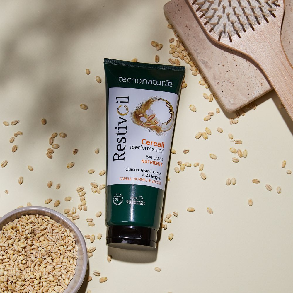 Tubo verde con cereali e spazzola per capelli. Prodotto per capelli normali e secchi. Su sfondo chiaro.
