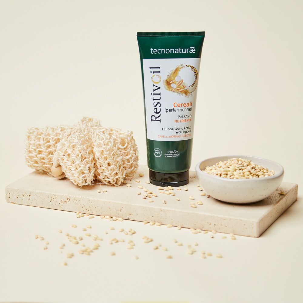 Tubo verde con cereali e spugne. Prodotto per capelli normali e secchi. Su sfondo chiaro.