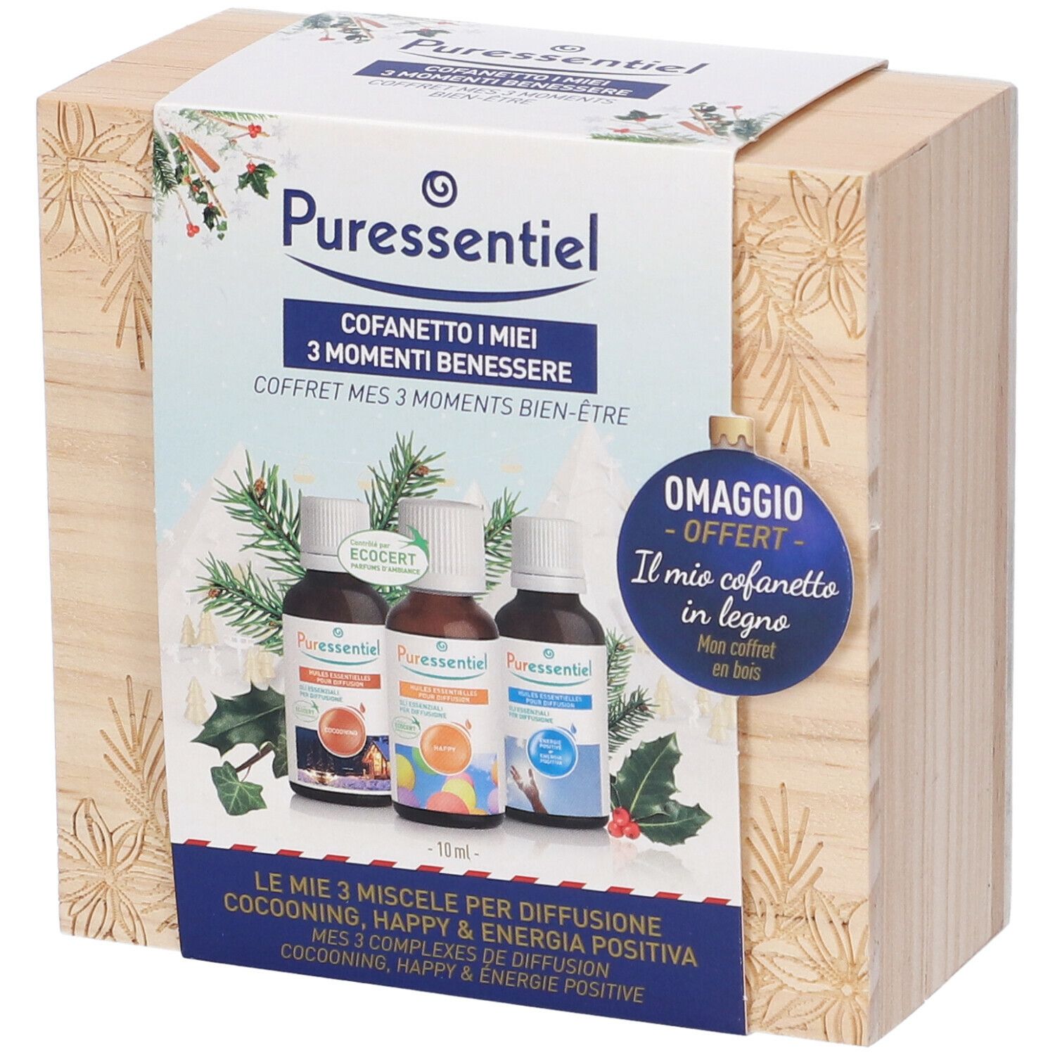 Scatola di legno con confezione del prodotto. Scritta: Puressentiel, Cofanetto I miei 3 Momenti Benessere. Decorata con rami di pino e agrifoglio.