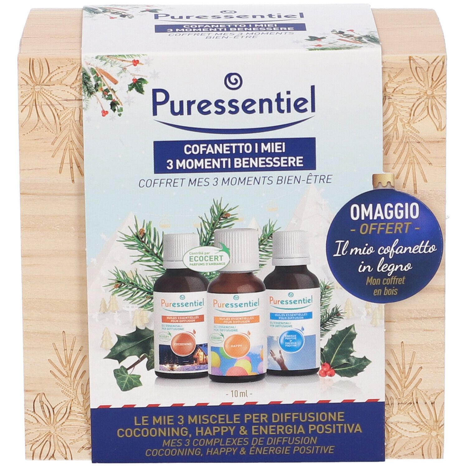 Scatola di legno con tre flaconi. Scritta: Puressentiel, Cofanetto I miei 3 Momenti Benessere. Decorata con rami di pino e agrifoglio.