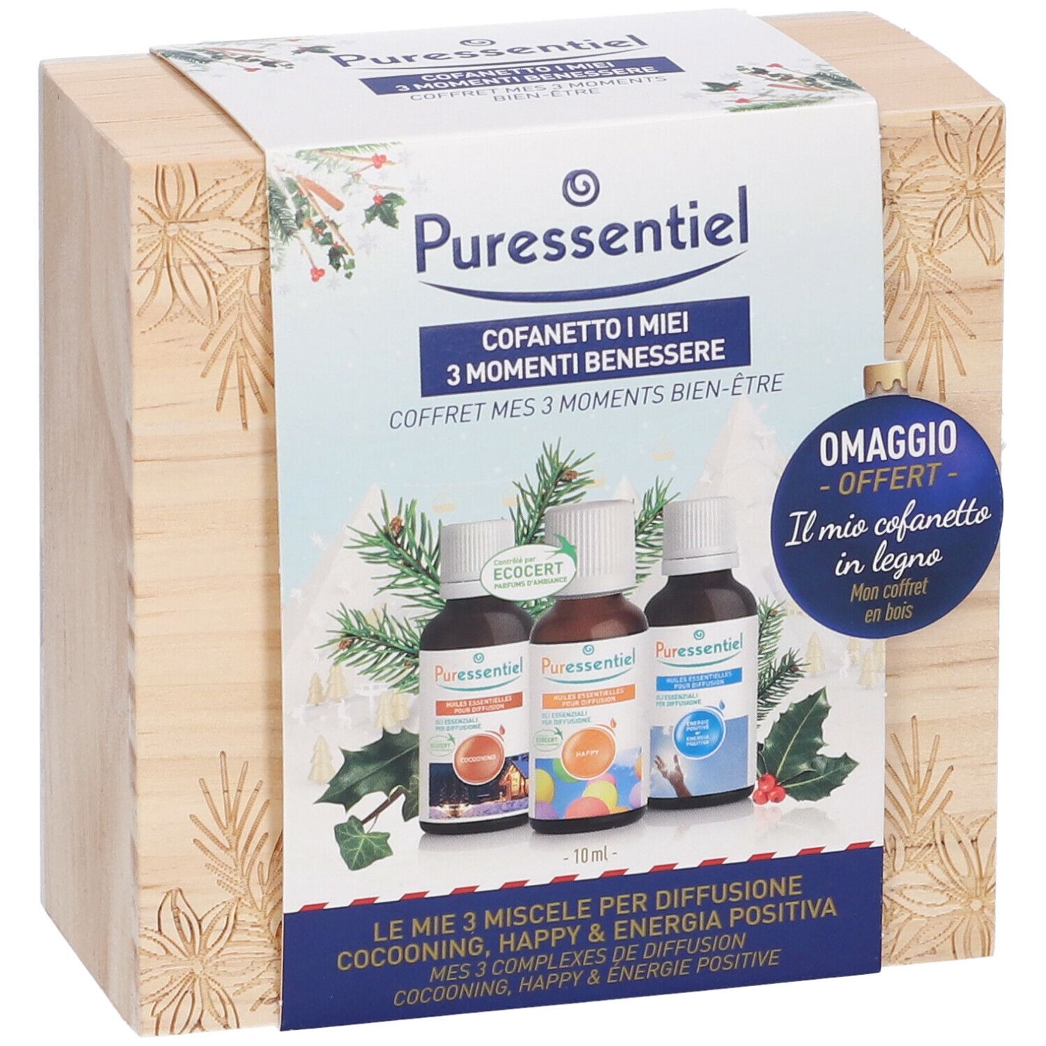 Scatola di legno con tre flaconi. Scritta: Puressentiel, Cofanetto I miei 3 Momenti Benessere. Decorata con rami di pino e agrifoglio.