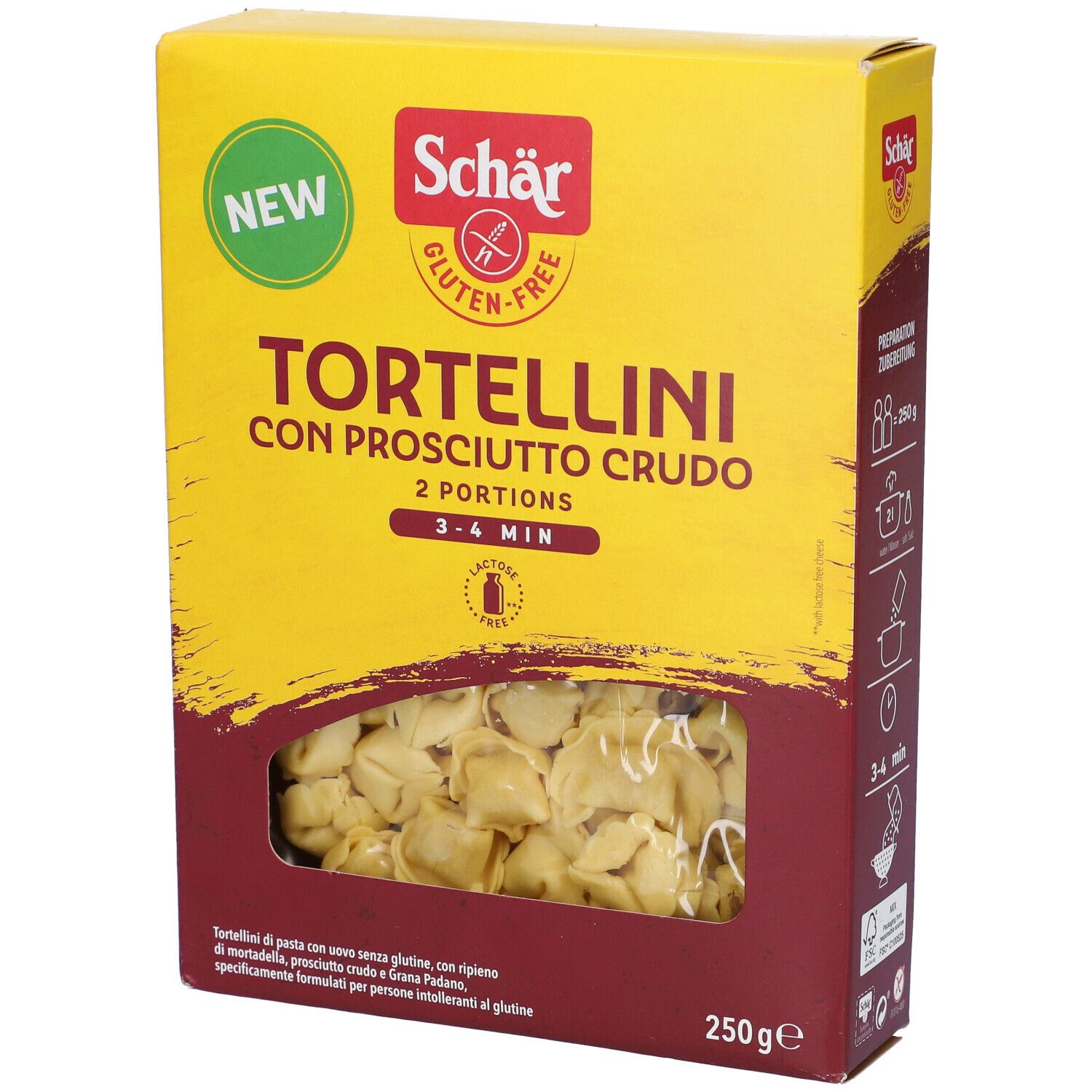 Scatola gialla di tortellini. Scritto: Schar, senza glutine, Tortellini con Prosciutto Crudo, 2 porzioni, 3-4 min. Finestra con tortellini.