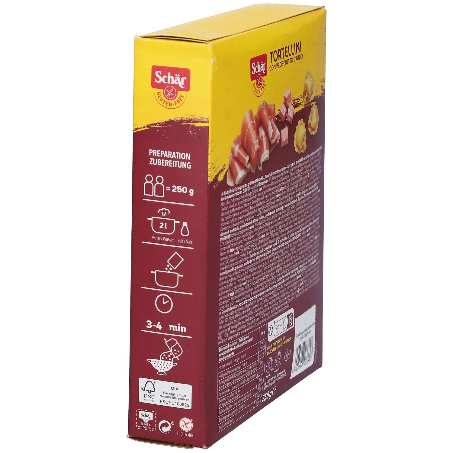 Scatola gialla di tortellini. Scritto: Schar, senza glutine, Tortellini con Prosciutto Crudo, 2 porzioni, 3-4 min. Istruzioni per la preparazione e ingredienti.