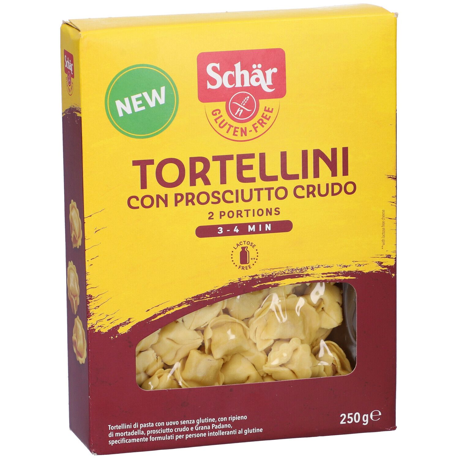 Scatola gialla di tortellini. Scritto: Schar, senza glutine, Tortellini con Prosciutto Crudo, 2 porzioni, 3-4 min. Finestra con tortellini.
