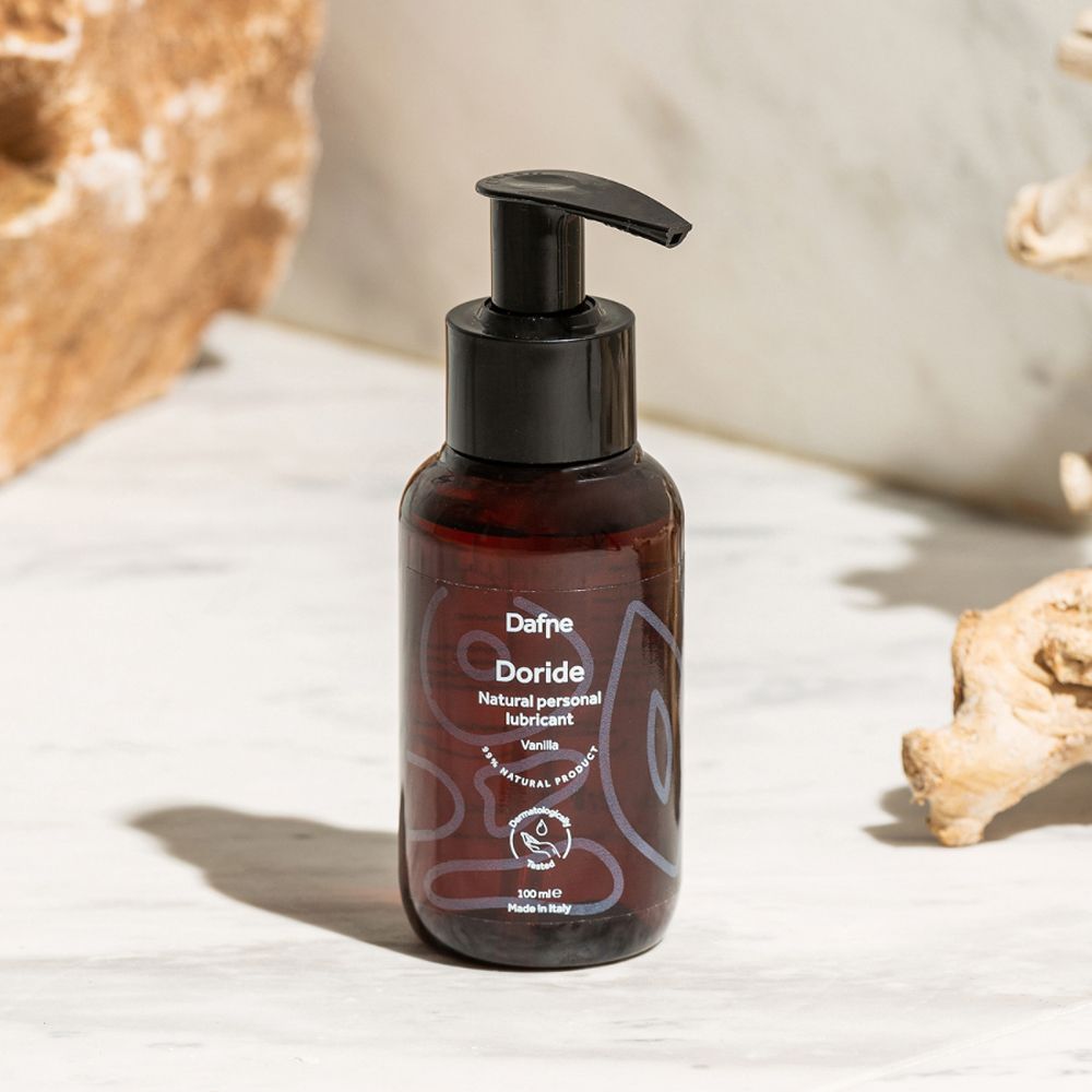 Flacone marrone con dispenser nero. Scritta: Dafne Doride Natural personal lubricant Vaniglia.