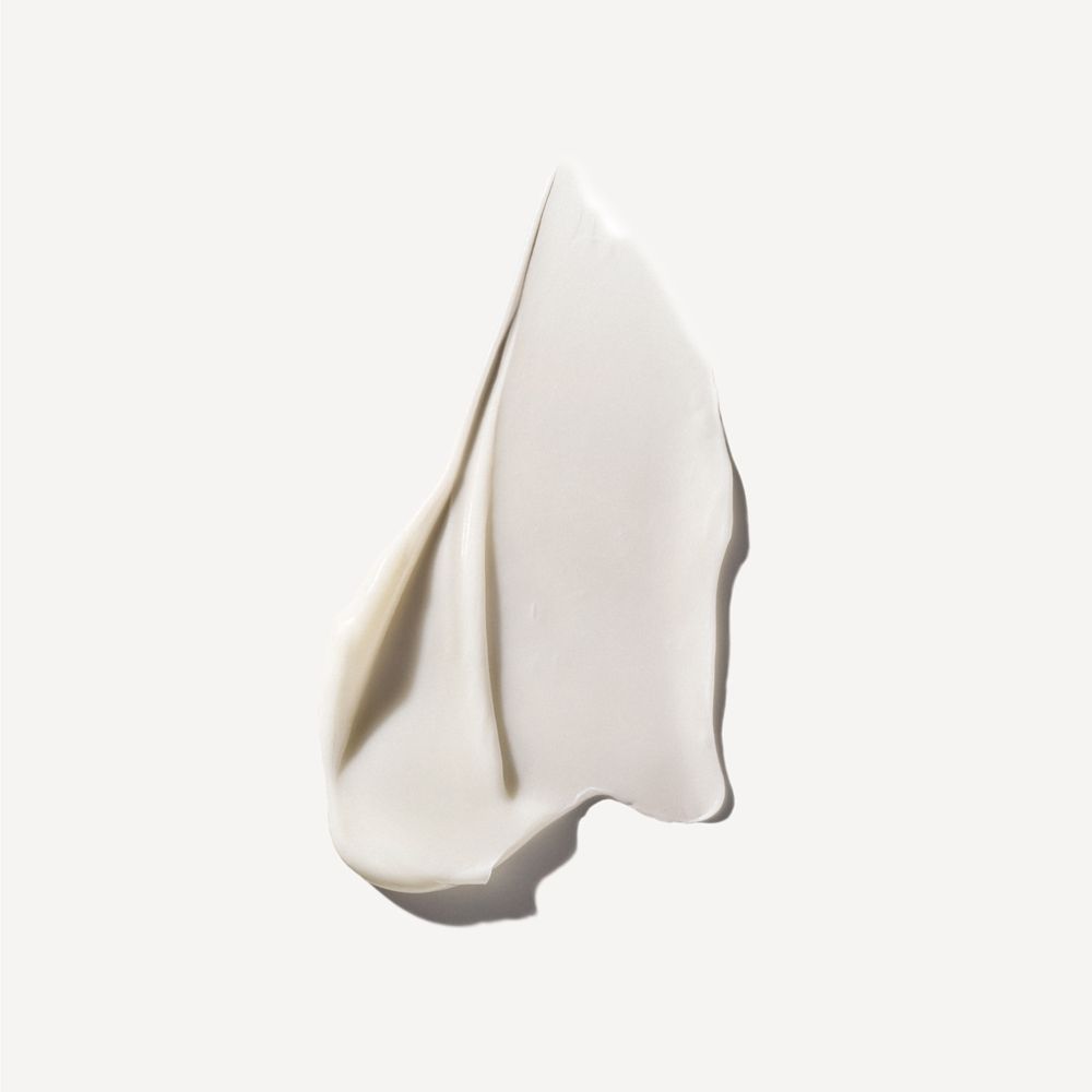 Nahaufnahme einer cremigen, weißen Substanz. Textur wie eine Creme oder ein Balsam. Auf hellem Hintergrund.