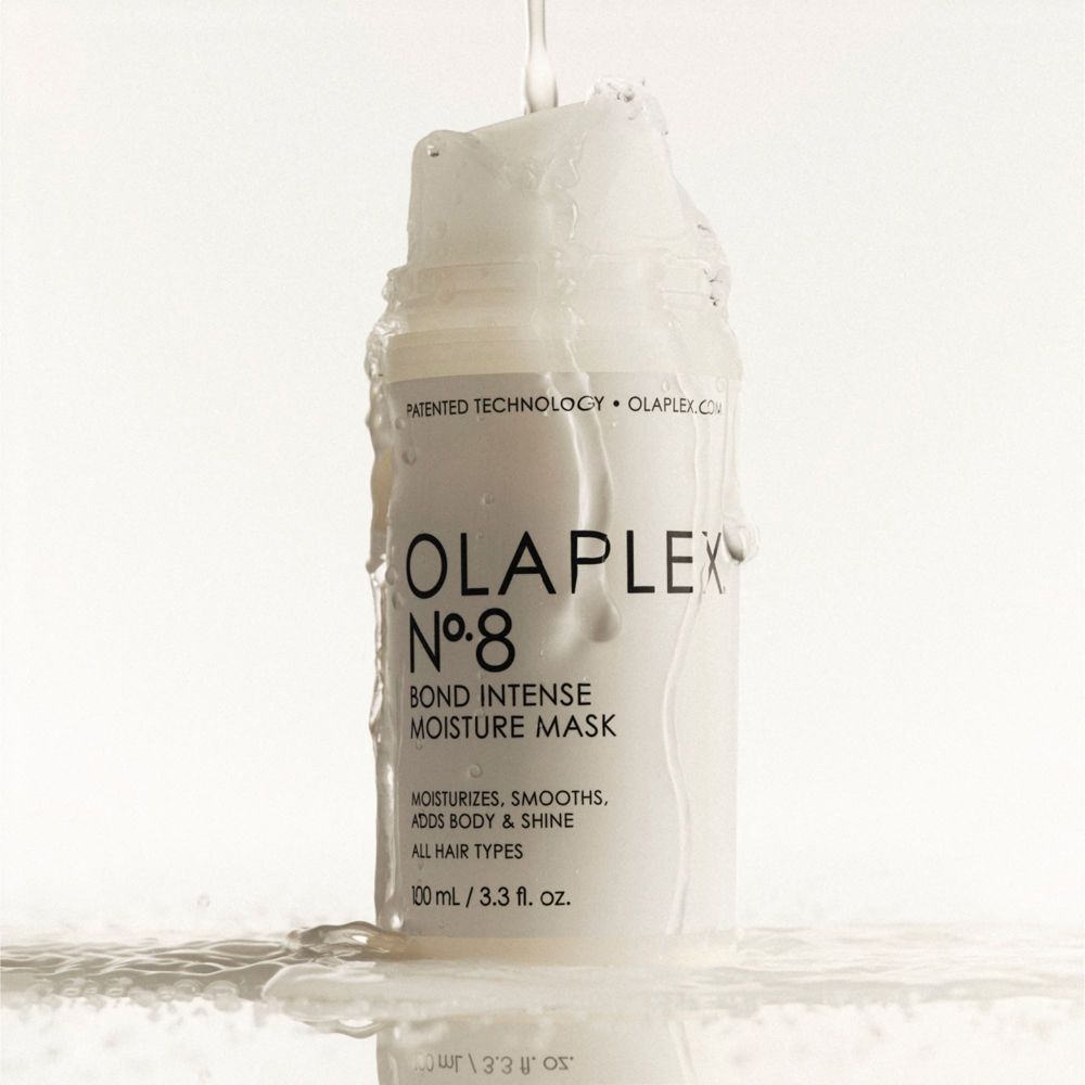 Weiße Flasche mit Klappdeckel. Wasser fließt über die Flasche. Aufschrift: Olaplex Nr. 8 Bond Intense Moisture Mask.