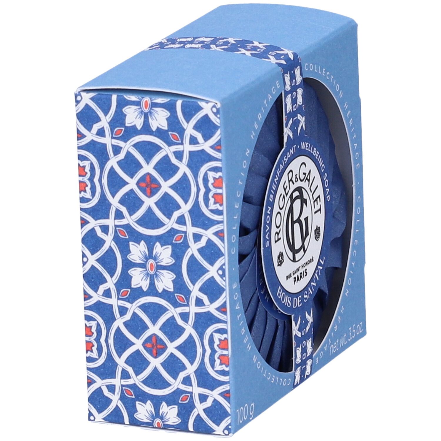 Scatola blu con motivo. Roger&Gallet Bois de Santal Saponetta. Sapone rotondo visibile. Confezione con nastro blu.