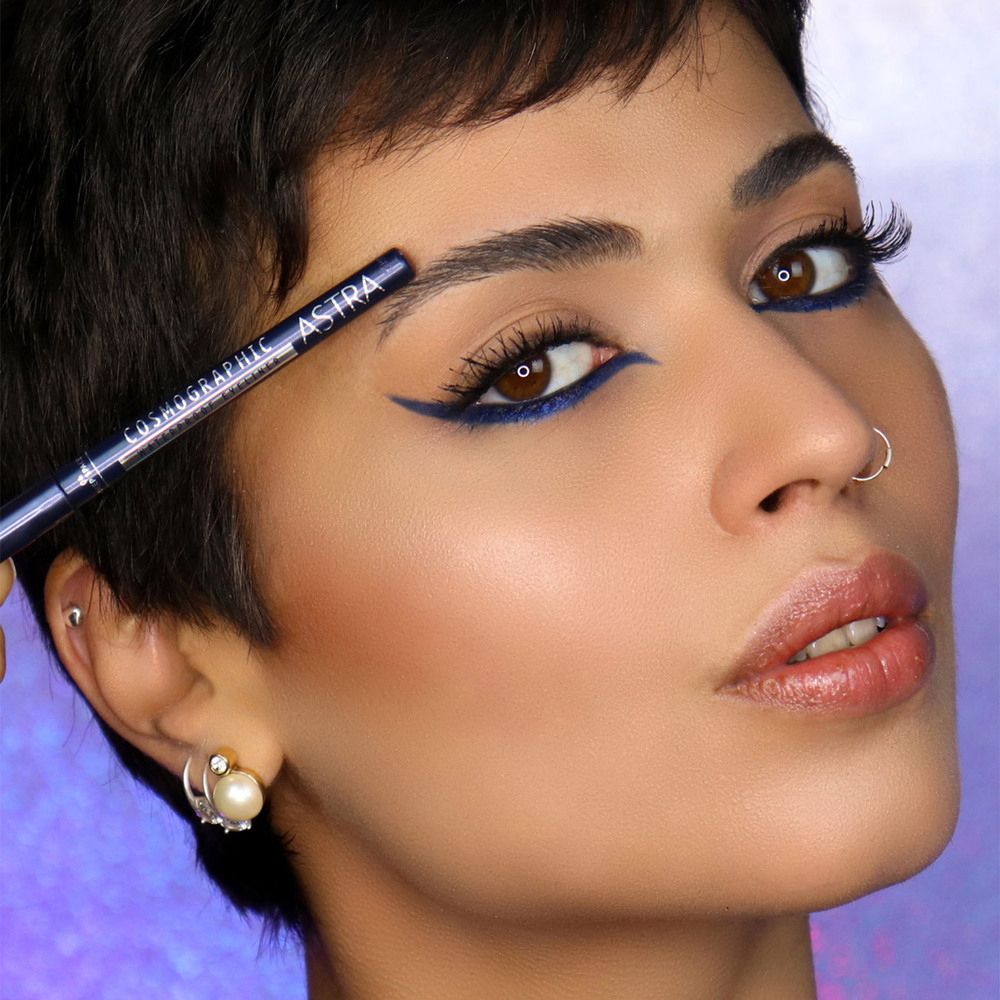 Donna con eyeliner blu. Matita occhi con scritta COSMOGRAPHIC ASTRA.