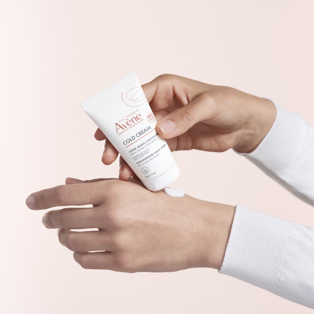 Person hält eine weiße Tube. Creme wird auf die Hand aufgetragen. Marke: Avène. Enthält Cold Cream.
