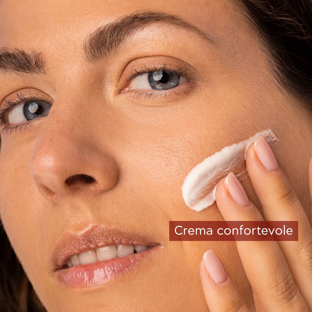 Donna applica crema. Vaso rosso APIVITA BEEVINE ELIXIR. Testo.