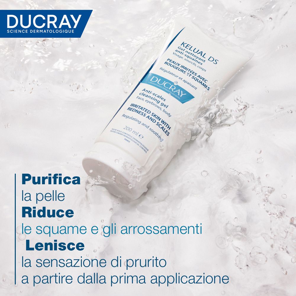 Pubblicità del prodotto con tubo bianco. Contiene "KELUAL DS" e "DUCRAY". L'acqua schizza sul prodotto. Testo: "Purifica la pelle".