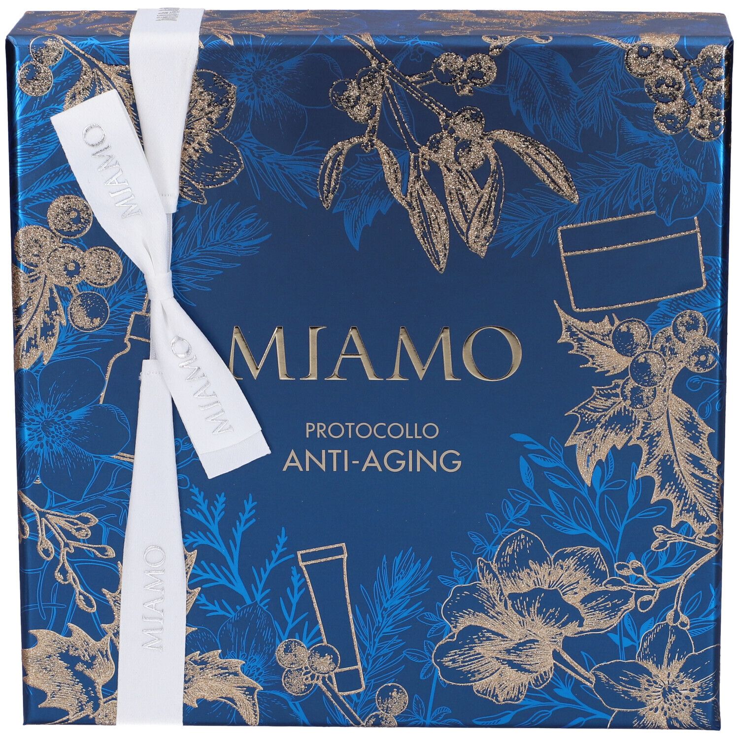 Confezione regalo blu con motivi floreali dorati e nastro bianco. Scritta: Miamo, Protocollo Anti-Aging. Vista dall'alto.