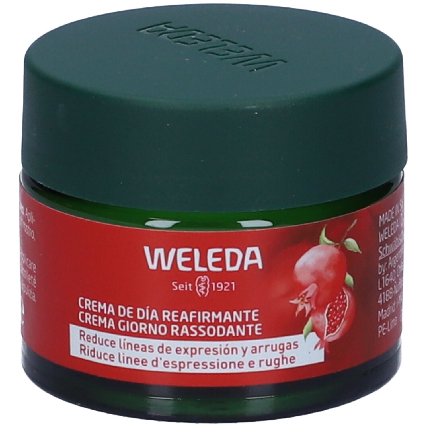 Vaso di vetro verde con coperchio verde scuro. Etichetta rossa con nome del prodotto e illustrazione di melograno. Marca Weleda.