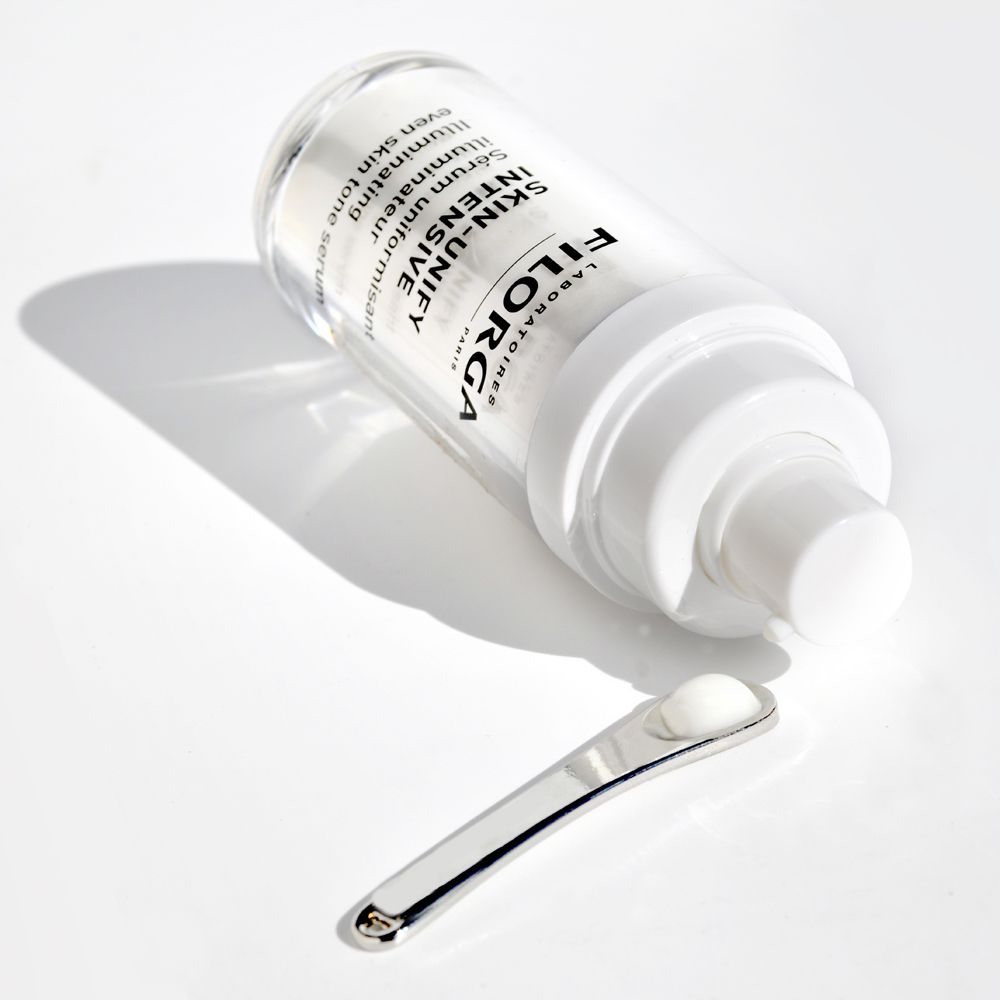 Flacone di siero Skin-Unify Intensive e spatola. Siero sulla spatola. Scritta: Filorga, Skin-Unify Intensive.