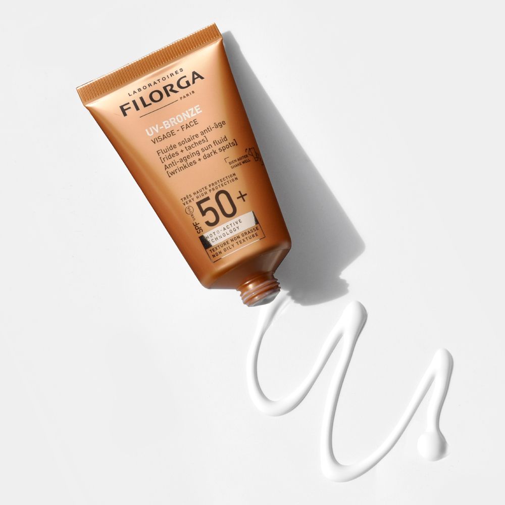 UV-Bronze Face SPF50+ in un tubo marrone. Scritte: UV-Bronze, Visage-Face, SPF 50+.