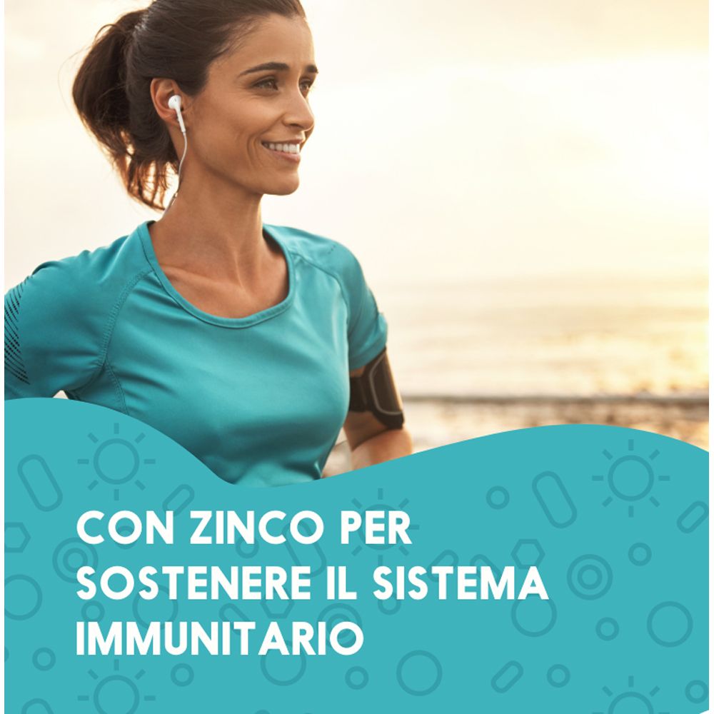 Donna che fa jogging al mare, cuffie. Testo: Con zinco per supportare il sistema immunitario.