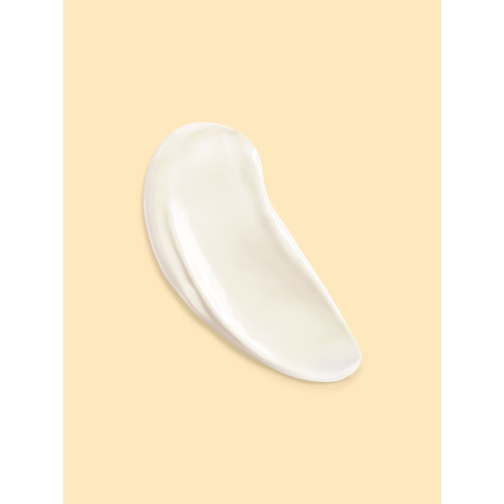 Macchia di crema bianca su sfondo beige. Consistenza visibile.