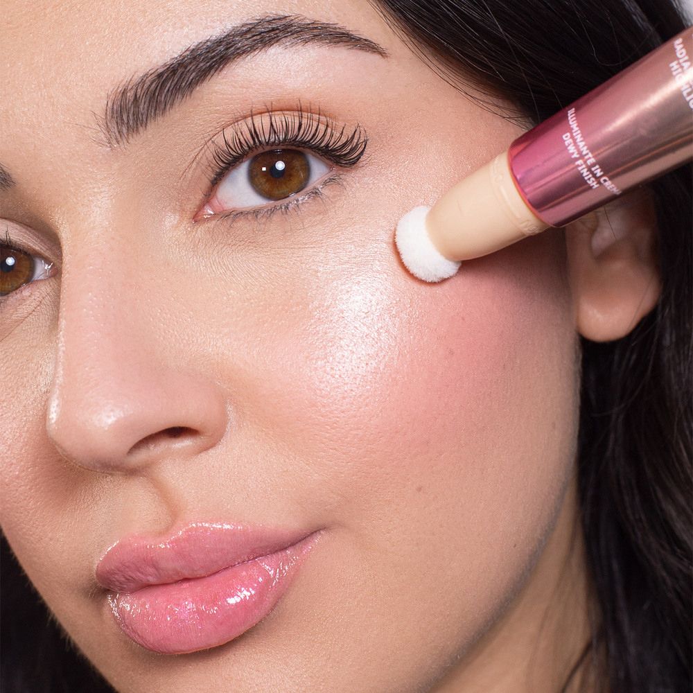Donna applica blush. Applicatore sulla guancia. ASTRA Make-Up Light Therapy. Tonalità rosa. Finitura luminosa.