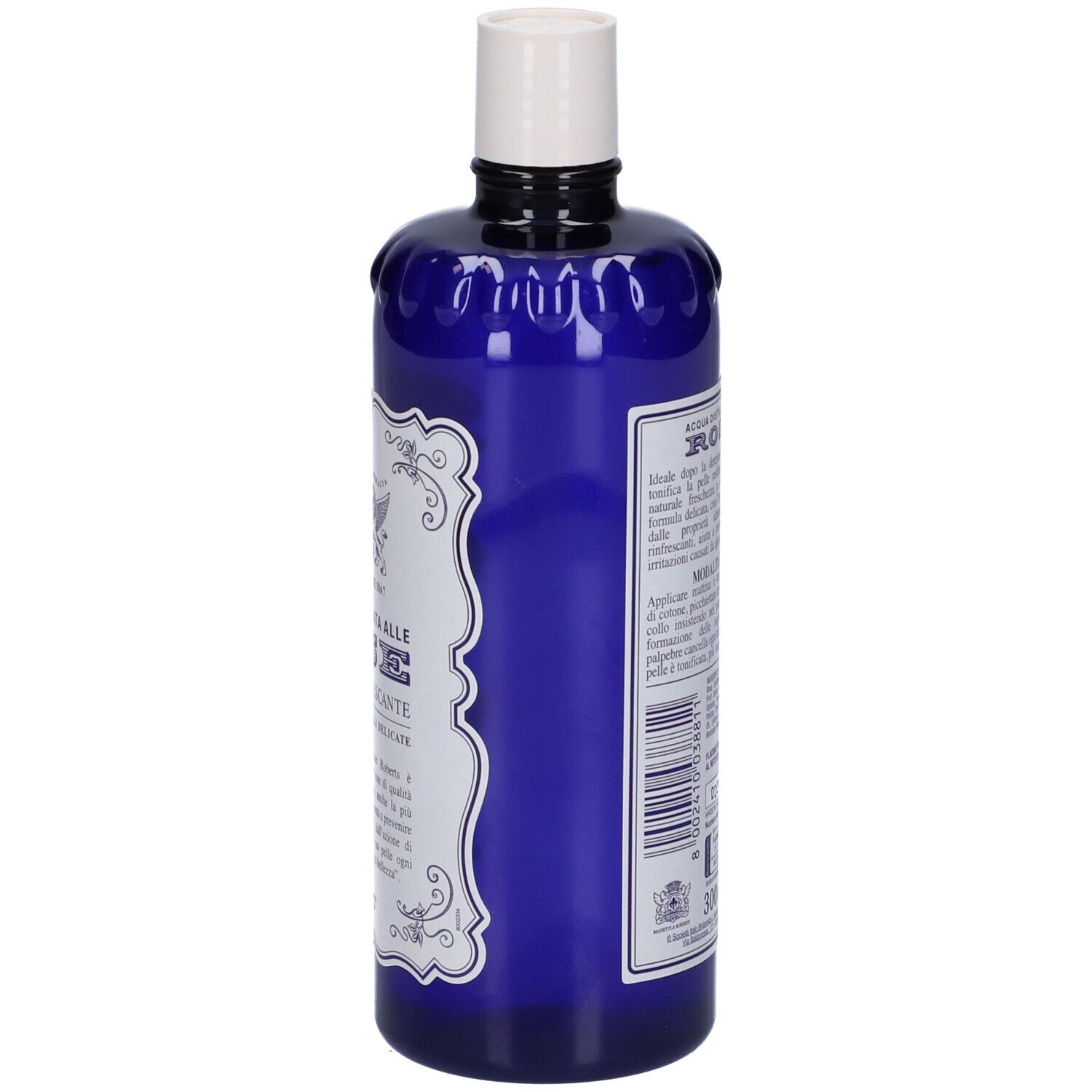 Bottiglia blu, vista laterale. Etichetta bianca con testo. Tappo bianco. Nome prodotto: Acqua Distillata Alle Rose Tonico Rinfrescante.