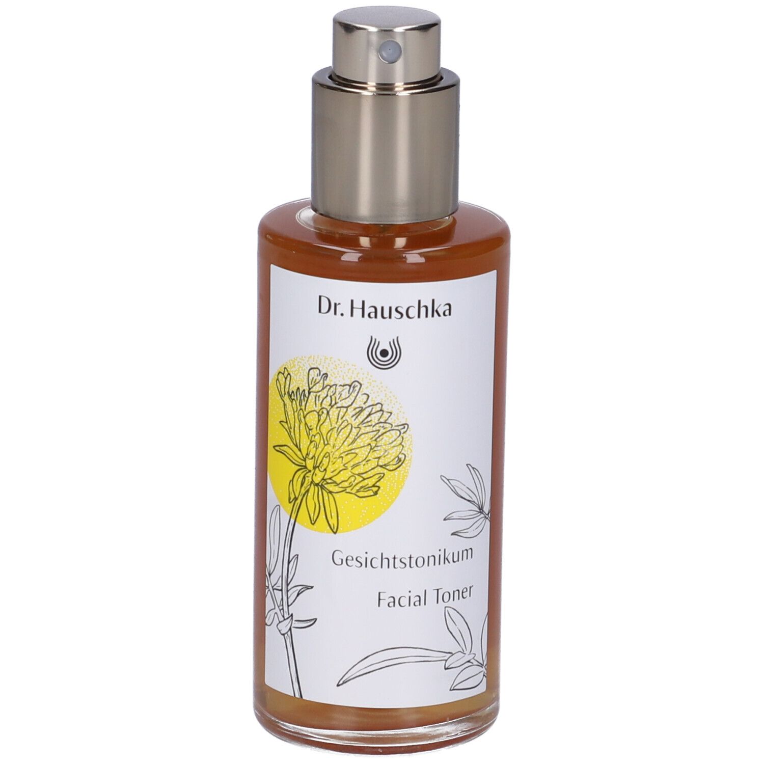 Flacone di vetro marrone con vaporizzatore. Etichetta con nome del prodotto e design floreale. Dr. Hauschka Facial Toner.