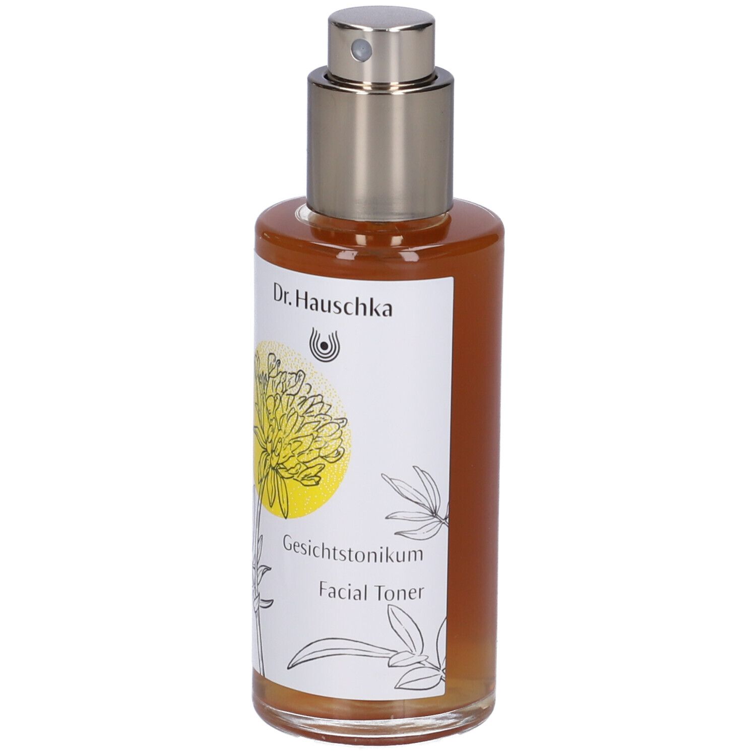 Flacone di vetro marrone con vaporizzatore. Etichetta con nome del prodotto e design floreale. Dr. Hauschka Facial Toner.