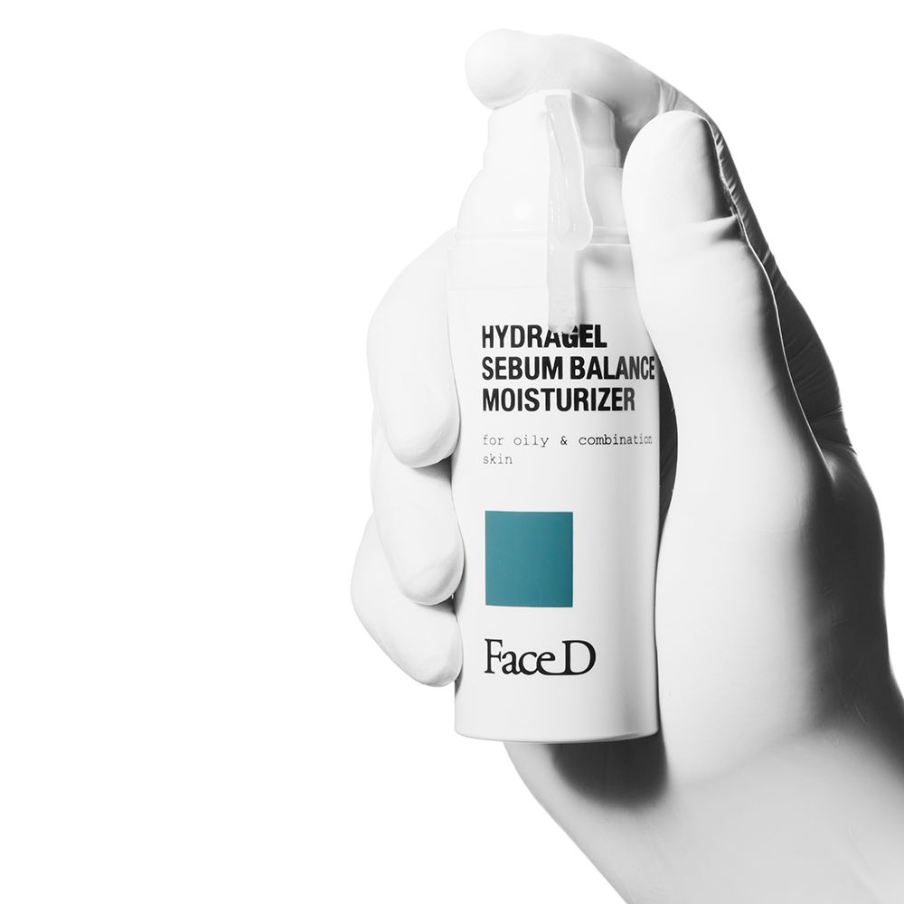 Weißes Produkt in einer Hand. Aufschrift: HYDRAGEL SEBUM BALANCE MOISTURIZER. Marke: Face D.
