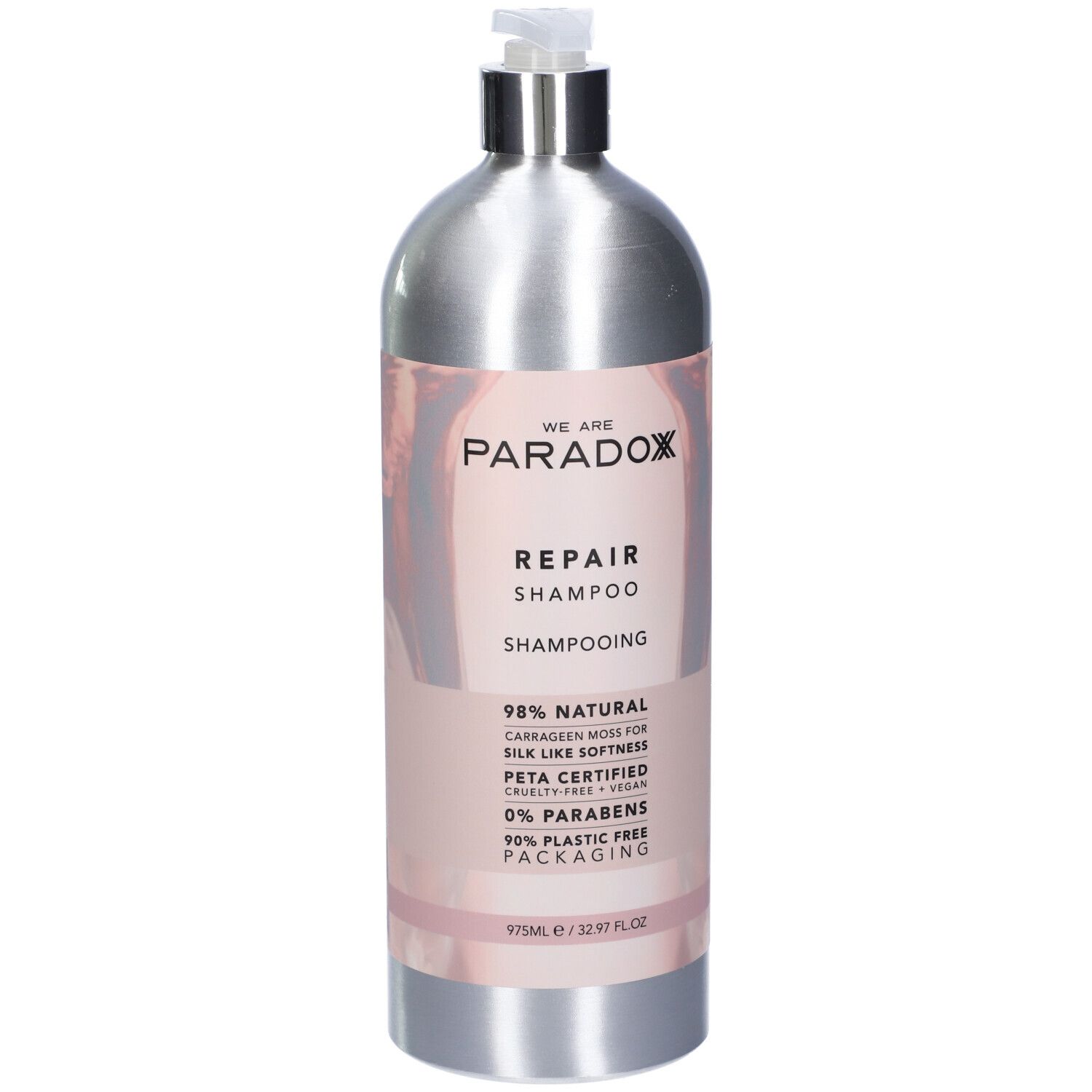 Flacone di shampoo argento con etichetta rosa. Scritta: WE ARE PARADOX REPAIR SHAMPOO. Certificazione PETA. 975ml.