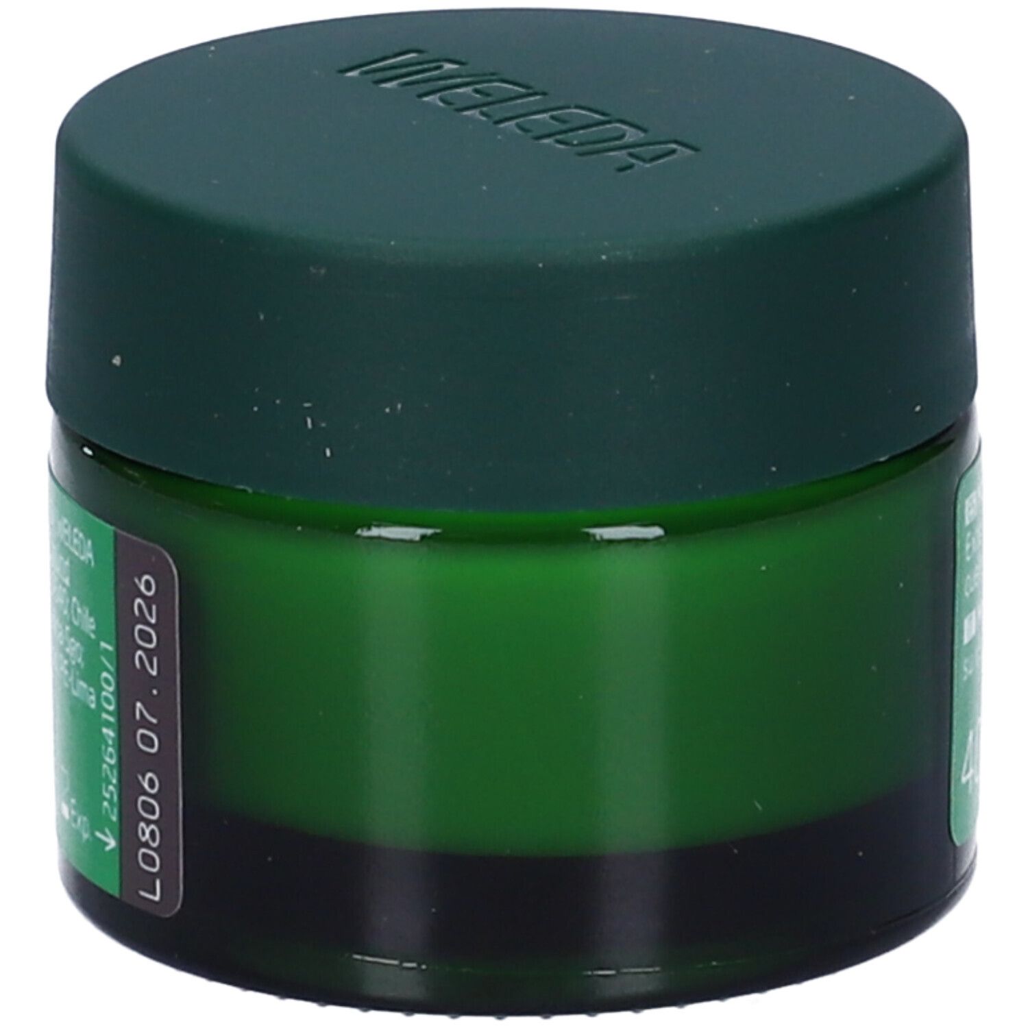 Vasetto verde con coperchio. Scritta: WELEDA. Etichetta con data di scadenza.