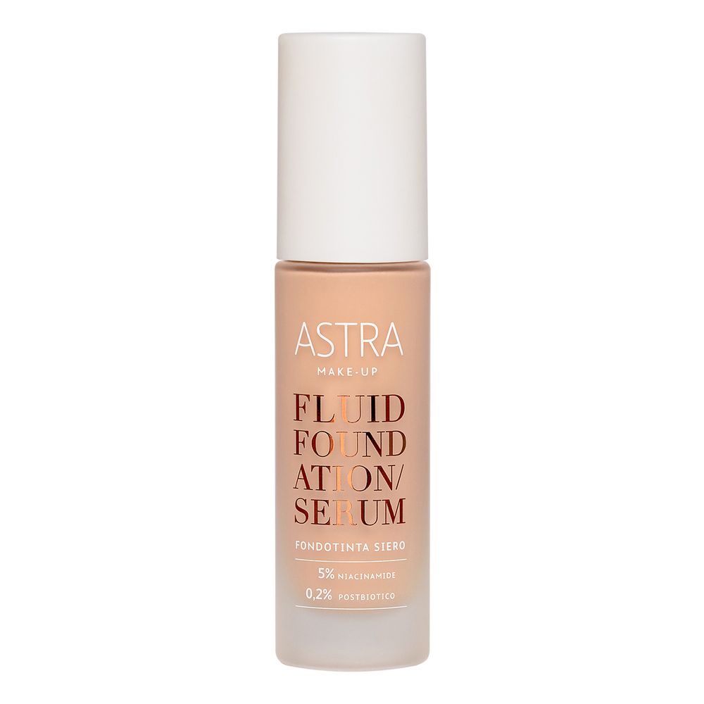 Flacone siero fondotinta beige con tappo bianco. Scritta: ASTRA MAKE UP, FLUID FOUNDATION/SERUM, 5% Niacinamide, 0,2% Postbiotico.