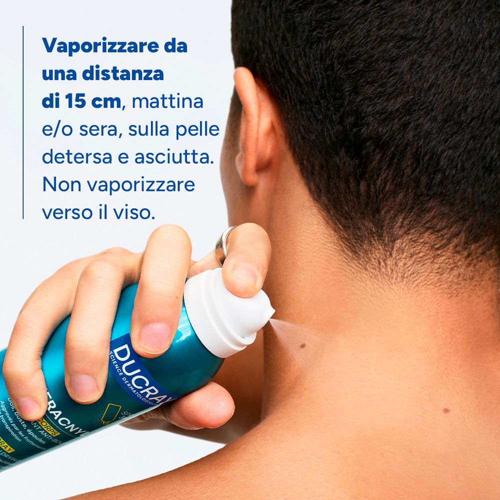 Primo piano: applicazione spray Ducray Keracnyl sul collo. Testo sulle istruzioni d'uso.