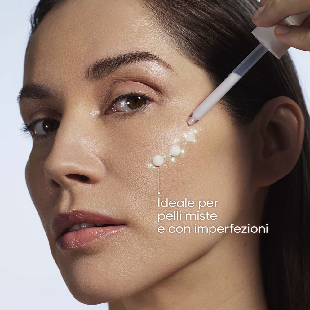 Applicazione OMIA Siero Viso Anti-Imperfezioni: pipetta applica il siero sulla pelle di una donna. Ideale per pelli miste.
