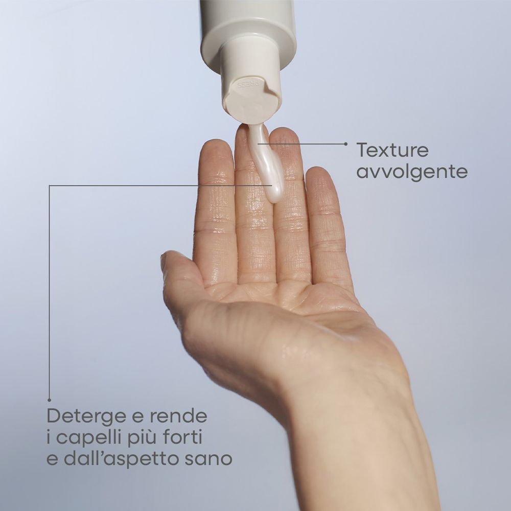 Una mano riceve un liquido bianco e cremoso da un dispenser.