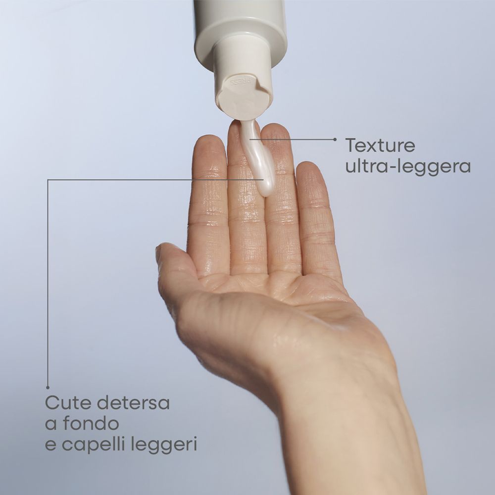 Una mano riceve un liquido bianco leggero da un dispenser.